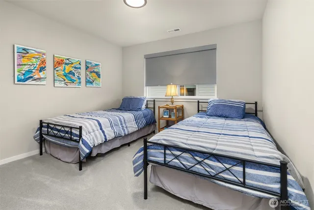 a bedroom with 2 bed and a dresser