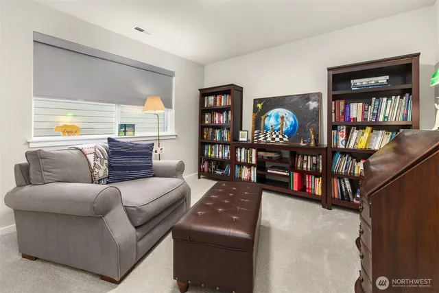a living room with couch a bookshelf and a window