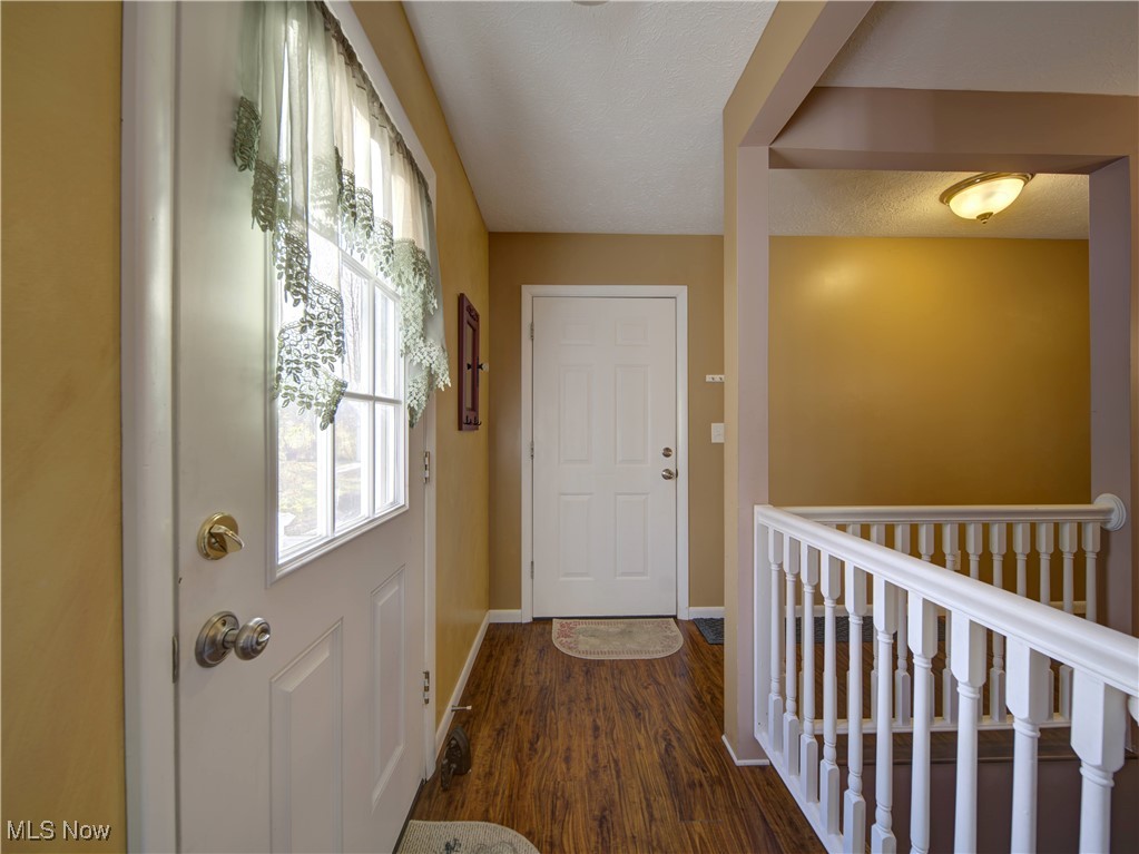 17161 Burrows Road Thompson, OH 44086 - Photo 21 of 48 Doorway with dark wood-type flooring and a textured ceiling