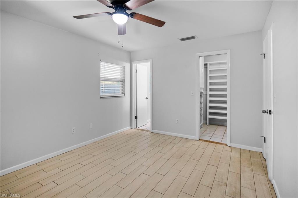 3581 Corana Way Naples, FL 34105 - Photo 11 of 26 wooden floor in an empty room with a window