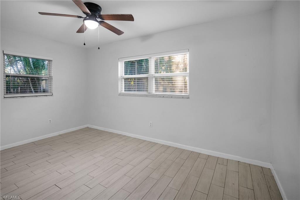 3581 Corana Way Naples, FL 34105 - Photo 12 of 26 wooden floor in an empty room with a window