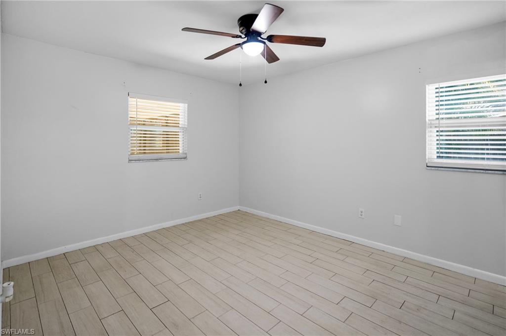 3581 Corana Way Naples, FL 34105 - Photo 13 of 26 wooden floor in an empty room with a window