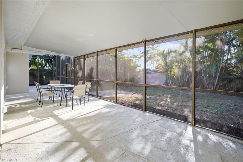 3581 Corana Way Naples, FL 34105 - Photo 18 of 26 a dining room with glass windows and chairs