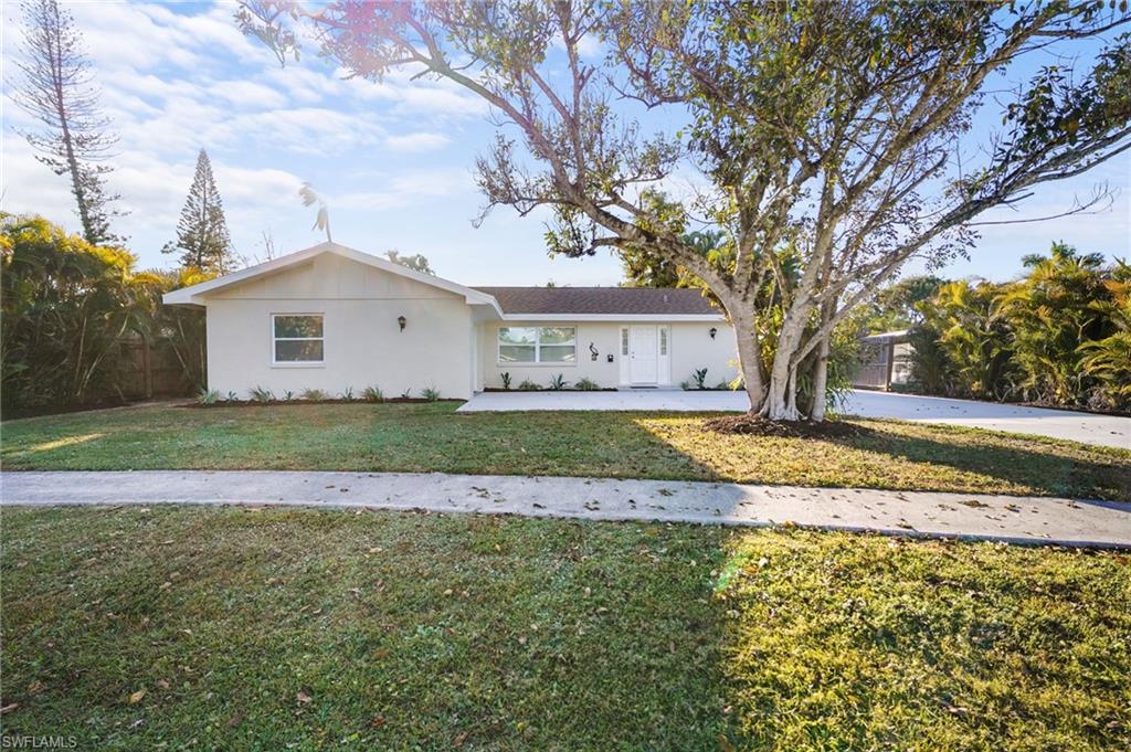 3581 Corana Way Naples, FL 34105 - Photo 2 of 26 a view of a house with a yard and large trees