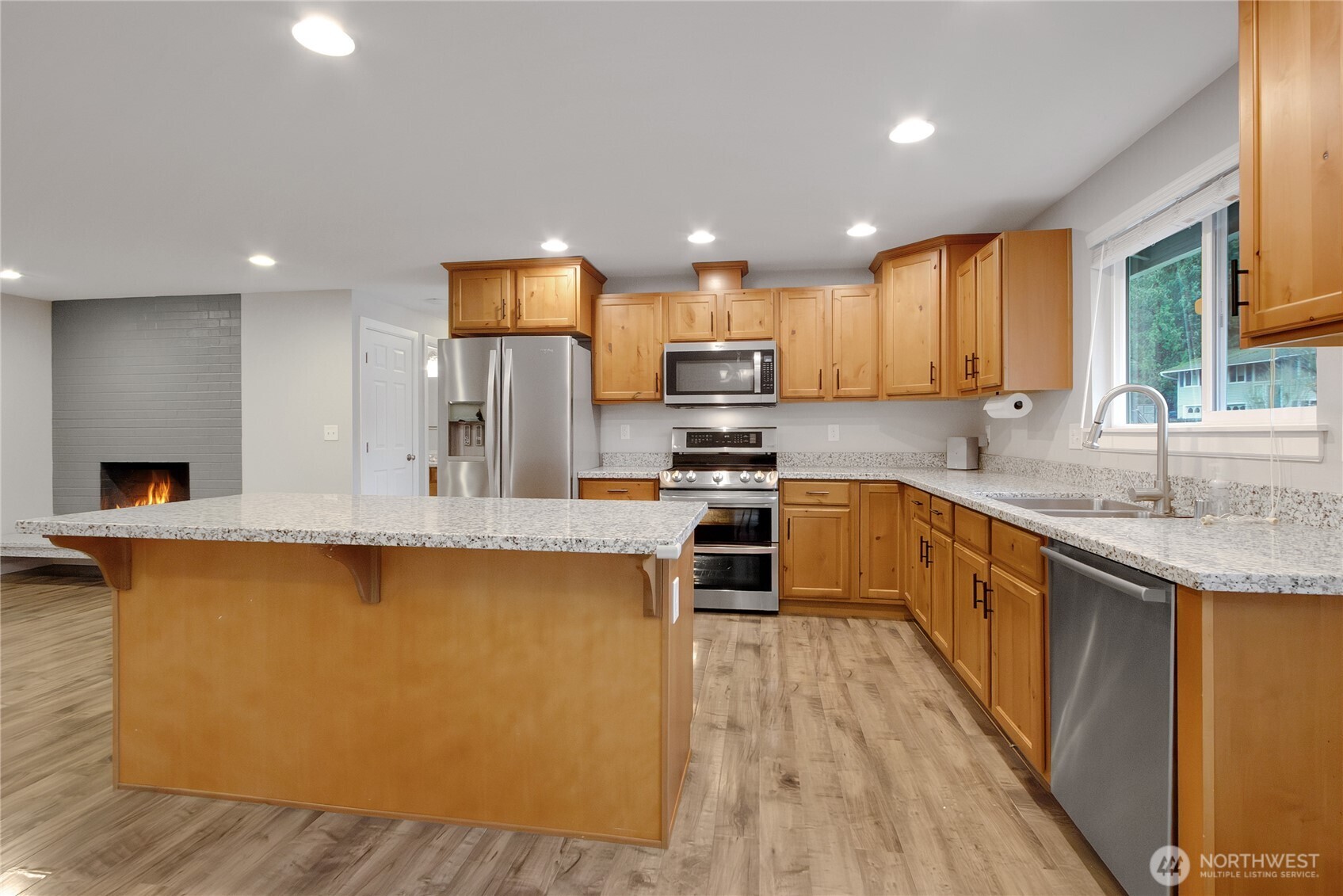 30331 9th Avenue South Federal Way, WA 98003 - Photo 9 of 36 a kitchen with stainless steel appliances granite countertop wooden cabinets a stove top oven a sink and dishwasher with wooden floor