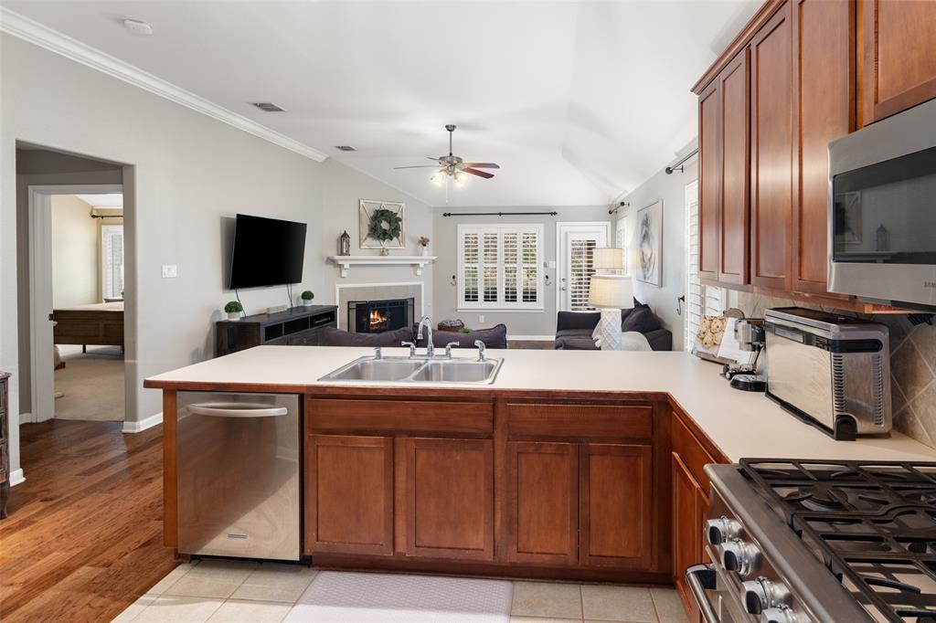 7604 Uvalde Way McKinney, TX 75071 - Photo 6 of 34 Stainless DCS Fisher and Paykel Gas Range, Microwave with vent, Open to Breakfast Room and Living Area.
