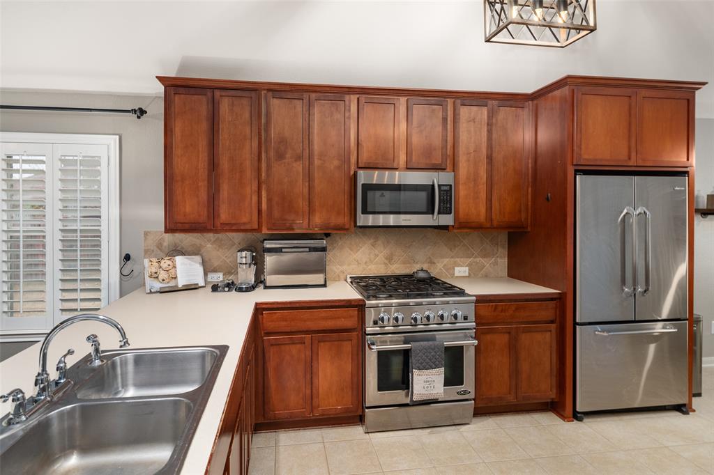 7604 Uvalde Way McKinney, TX 75071 - Photo 7 of 34 Kitchen features decorative lighting, Pantry, View to Living and Breakfast Areas.