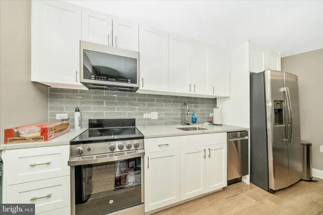 a kitchen with stainless steel appliances granite countertop a refrigerator and a stove