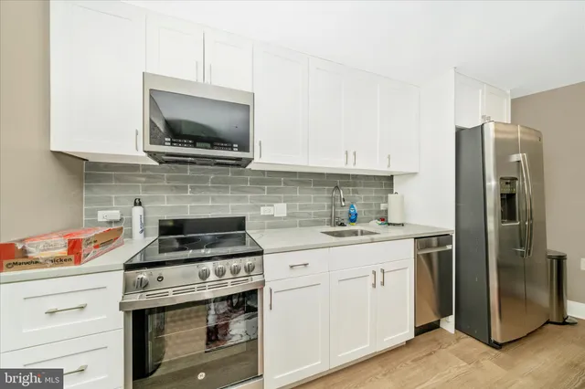 a kitchen with stainless steel appliances granite countertop a refrigerator stove and sink