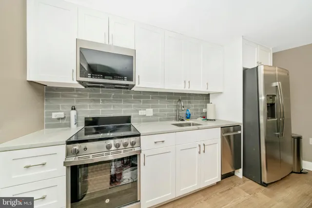 a kitchen with a refrigerator and a stove top oven