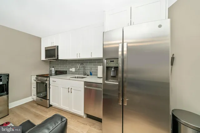 a kitchen with stainless steel appliances granite countertop a stove a refrigerator and a microwave