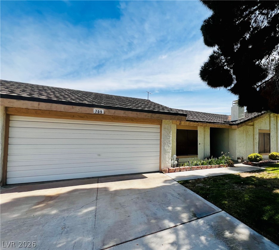709 Ridgemount Drive Las Vegas, NV 89107 - Photo 11 of 40 View of front of house with concrete driveway, an attached garage, and a shingled roof
