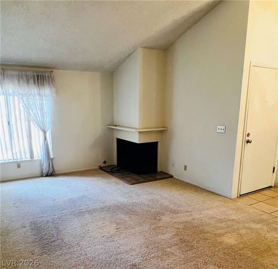 709 Ridgemount Drive Las Vegas, NV 89107 - Photo 13 of 40 Front facing living room with fireplace, vaulted ceiling.