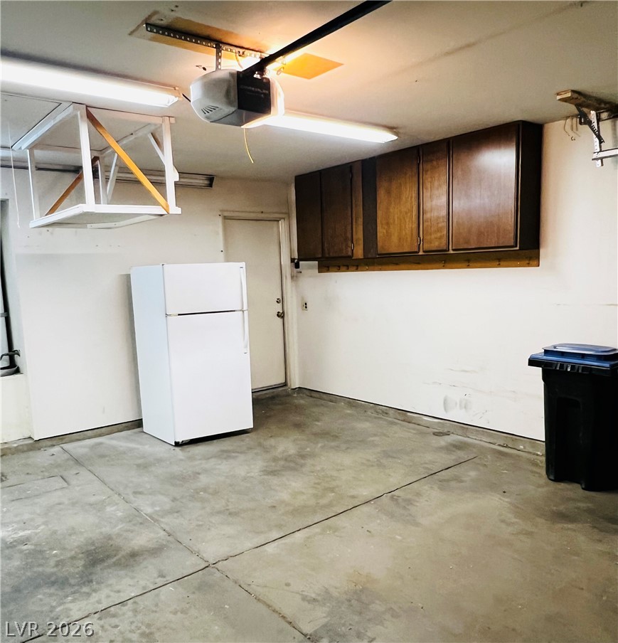 709 Ridgemount Drive Las Vegas, NV 89107 - Photo 18 of 40 Garage with freestanding refrigerator and a garage door opener