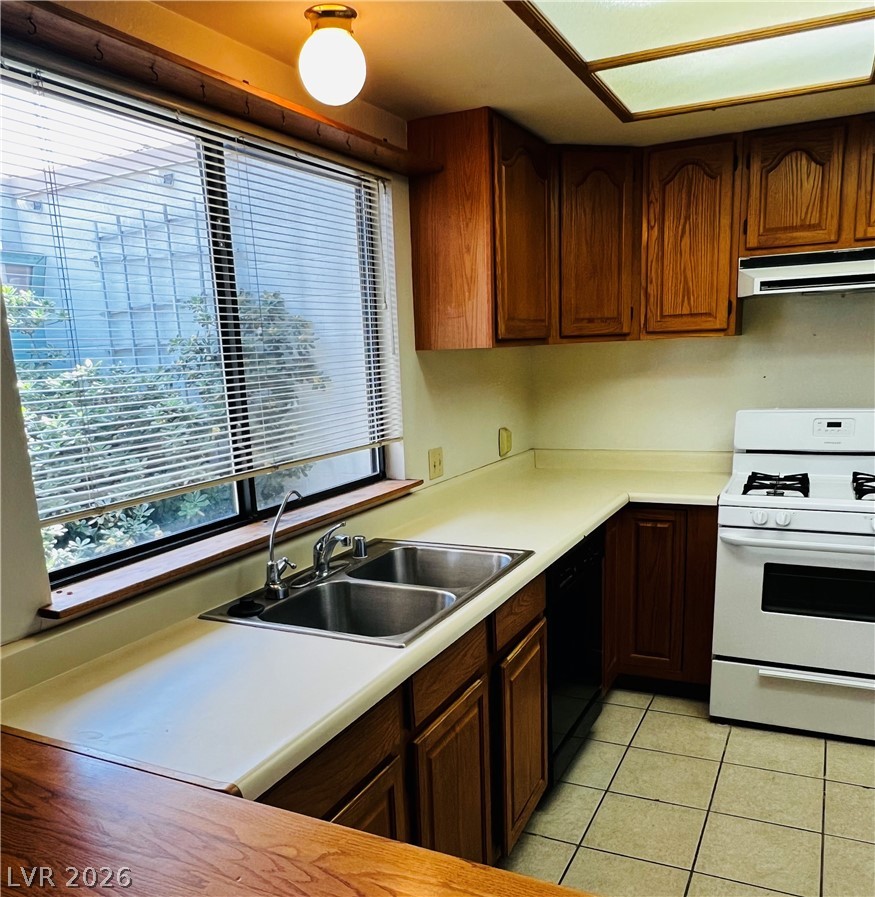 709 Ridgemount Drive Las Vegas, NV 89107 - Photo 3 of 40 Kitchen featuring white gas stove, light countertops, dishwasher, and light tile patterned flooring
