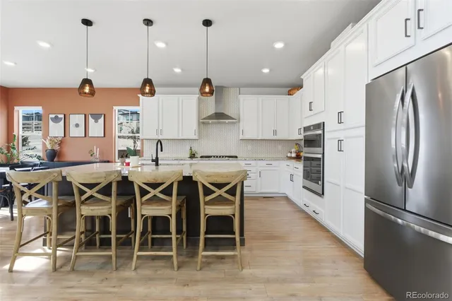 a kitchen with stainless steel appliances granite countertop a stove refrigerator and cabinets