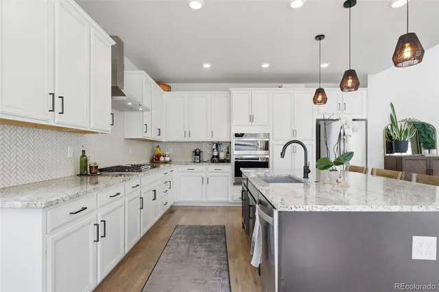 a kitchen with granite countertop a sink a stove and cabinets