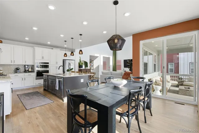 a kitchen with a dining table chairs stainless steel appliances and cabinets