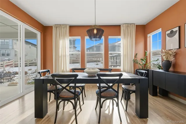 a view of a dining room with furniture and large windows