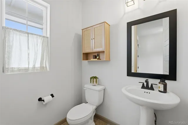 a bathroom with a toilet a sink a mirror and vanity