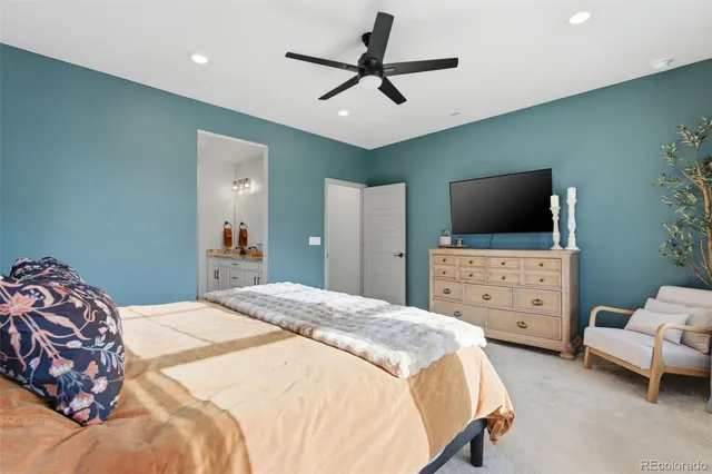 a spacious bedroom with a bed and a flat screen tv