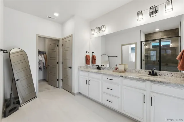 a bathroom with a granite countertop sink double vanity and a mirror