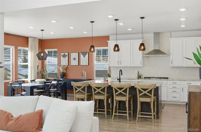 a large kitchen with lots of furniture and wooden floor