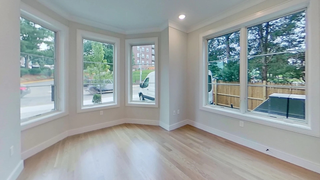 104-106 Warren Street, Unit 1 Boston, MA 02135 - Photo 1 of 6 an empty room with wooden floor and windows