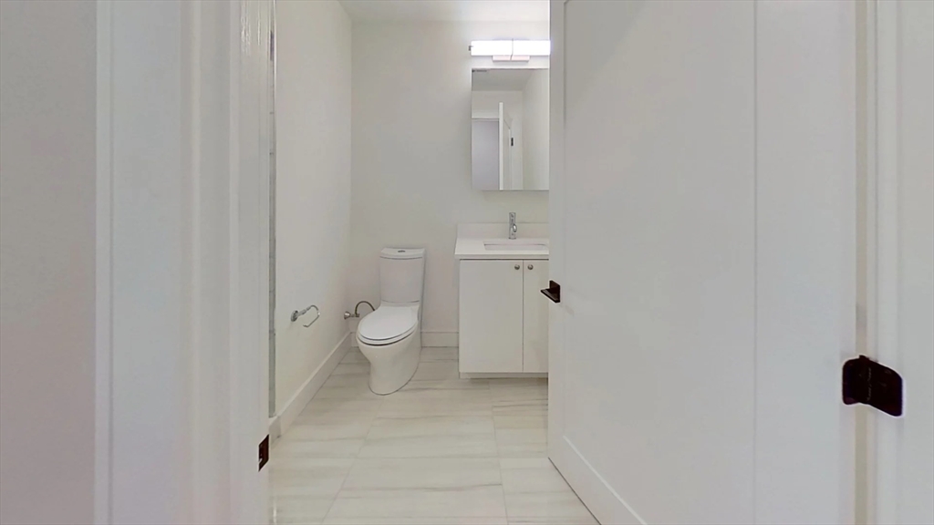 104-106 Warren Street, Unit 1 Boston, MA 02135 - Photo 4 of 6 a bathroom with a toilet and a sink