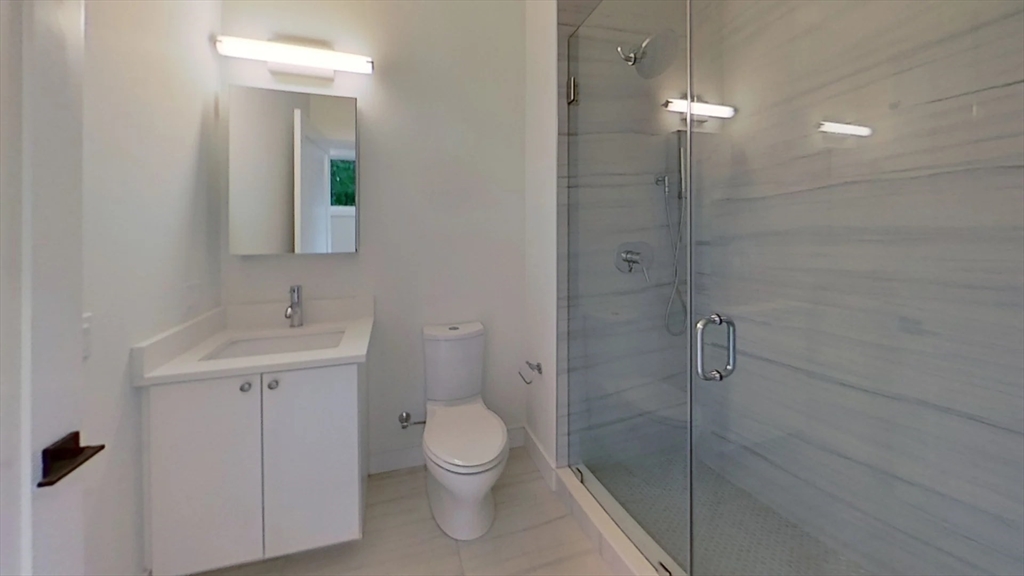 104-106 Warren Street, Unit 1 Boston, MA 02135 - Photo 5 of 6 a bathroom with a toilet sink and shower