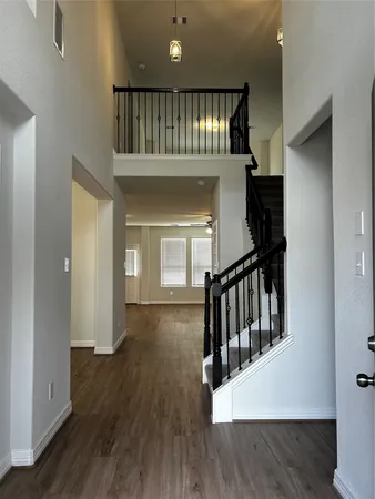 a view of staircase with railing and a chandelier