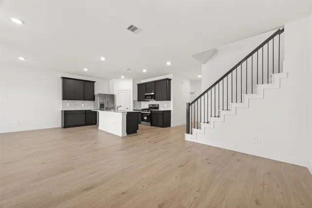 a large kitchen with kitchen island granite countertop a sink and appliances
