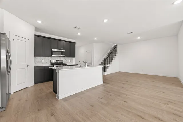 a kitchen with stainless steel appliances a refrigerator and cabinets