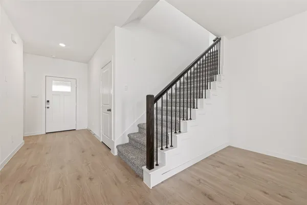 a view of a hallway with wooden floor and entryway