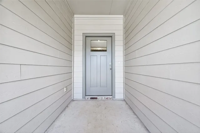 a view of a hallway with wooden floor and entryway