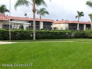 201 St Lucie Lane, Unit 209 Cocoa Beach, FL 32931 - Photo 1 of 11 a front view of a house with a garden