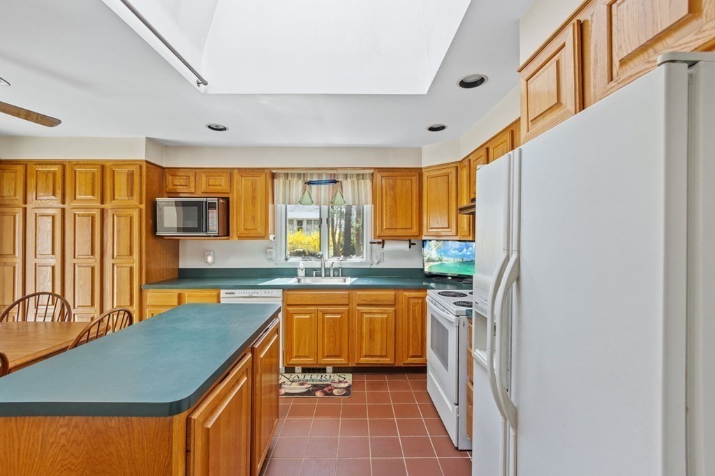 5 Bowler Road Wareham, MA 02571 - Photo 11 of 41 a kitchen with stainless steel appliances granite countertop a refrigerator a sink dishwasher a stove and a dining table with wooden floor