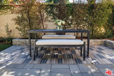 a balcony with wooden floor table and chairs