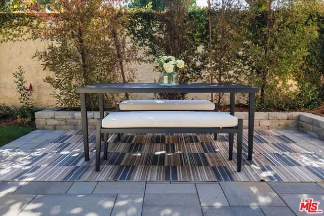 a balcony with wooden floor table and chairs