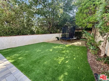 a view of a backyard with large trees