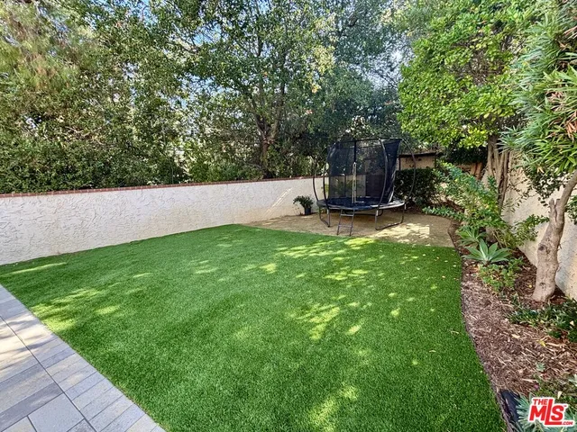 a view of a backyard with large trees