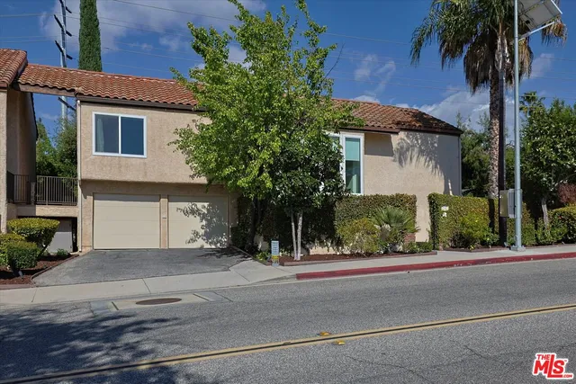 a front view of a house with a garden and a garage