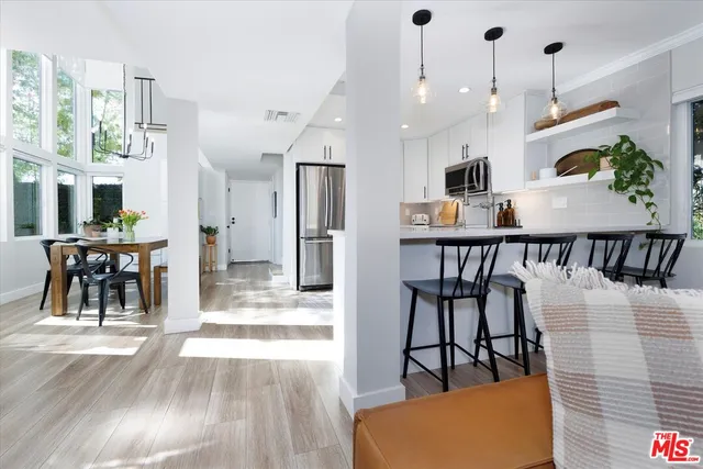 a view of a dining room and livingroom with furniture wooden floor a chandelier