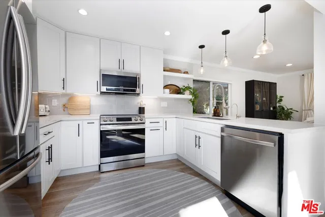 a kitchen with stainless steel appliances granite countertop a stove a sink and a refrigerator