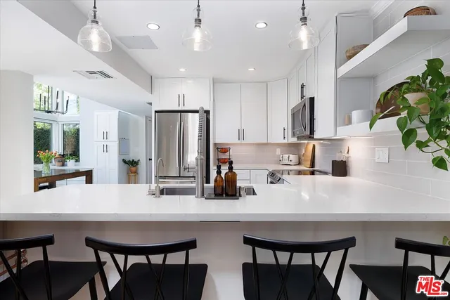 a kitchen with refrigerator and chairs