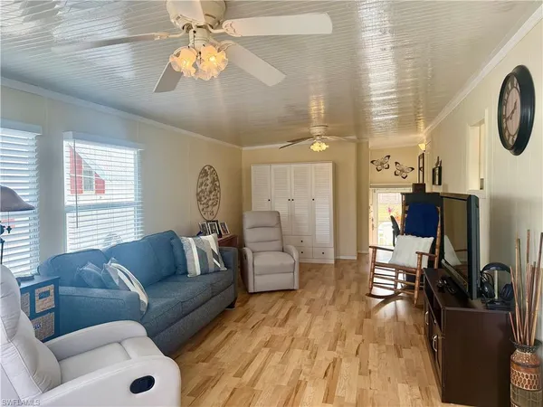 a living room with furniture a clock on wall and a window