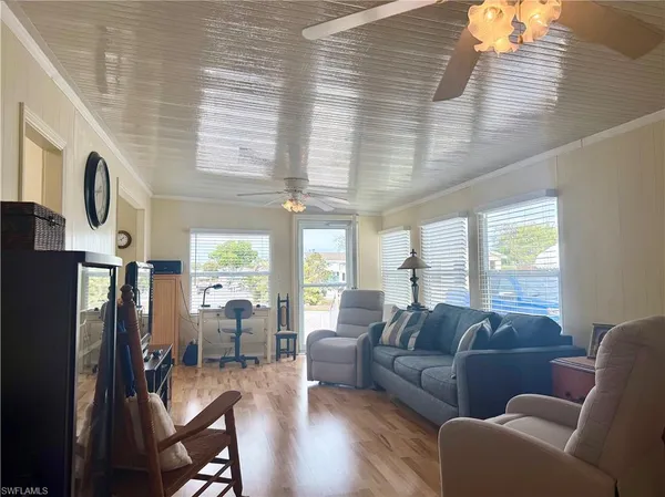 a living room with furniture wooden floor and a large window