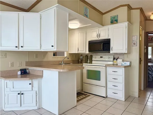 a kitchen with stainless steel appliances white cabinets and a stove top oven