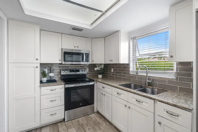 a kitchen with white cabinets and white appliances
