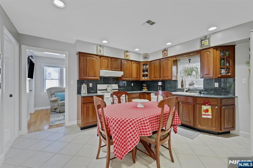 19 Hamilton Avenue Kearny, NJ 07032 - Photo 12 of 33 a kitchen with stainless steel appliances granite countertop a refrigerator a stove a sink a dining table and chairs